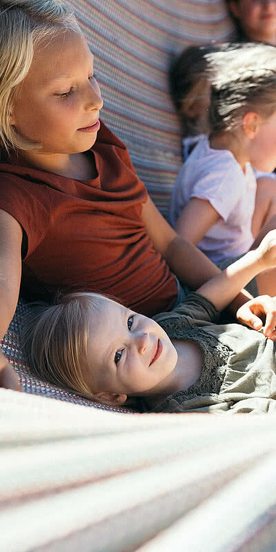 Familienzeit Deluxe Kinder in einer Hängematte beim Hotel Unterschwarzachhof in Saalbach Hinterglemm