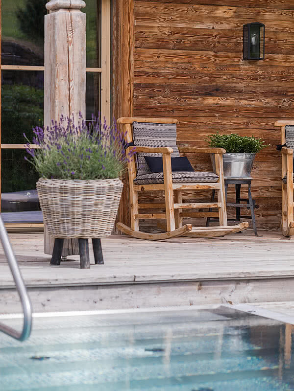 Ein Stuhl vor dem Pool in der Schmiedalm - dem Chalet in Saalbach Hinterglemm