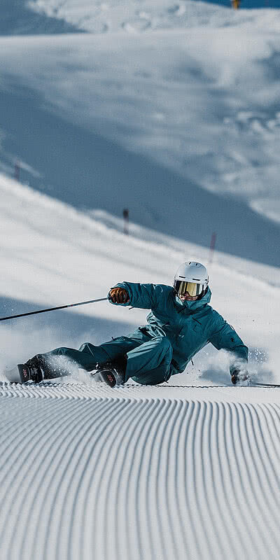 Ski-in & Ski-out Ein Skifahrer auf einer frisch preperierten Piste