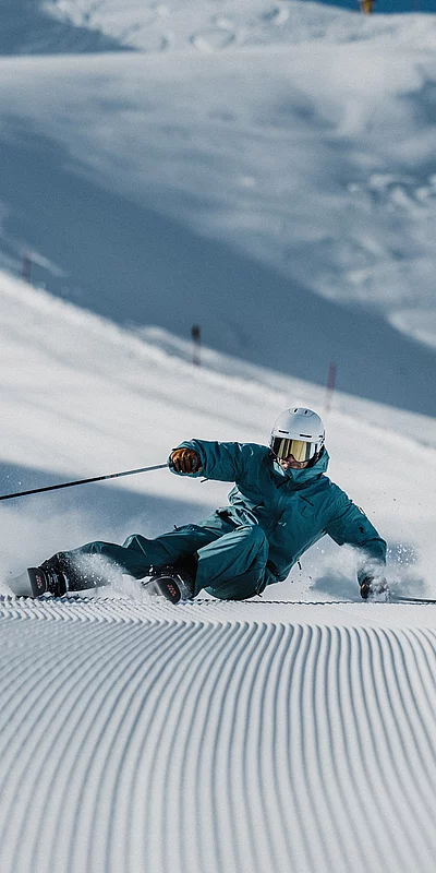 Ski-in & Ski-out Ein Skifahrer auf einer frisch preperierten Piste
