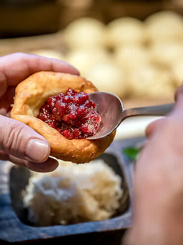 Persönlicher Service Ein Krapfen mit Preiselbeerenmarmelade in der Schmiedalm