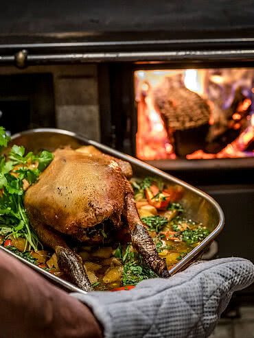 Kulinarische Genüsse Ein köstlich gefüllter Braten wird auf der Schmiedalm aus dem Holzofen genommen